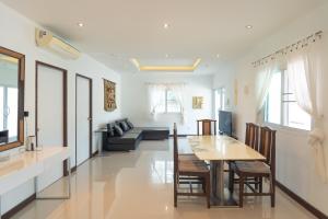 a dining room and living room with a table and chairs at JUNGLE APARTMENT2 BEDROOMS PRIVATE POOl in Kamala Beach