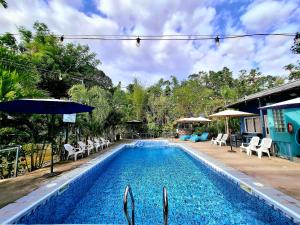 a pool with chairs and umbrellas next to a house at Hidden Palms Inn Garden Deluxe in San Juan