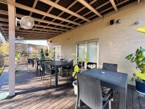 a patio with tables and chairs on a deck at SWELL in Hyuga