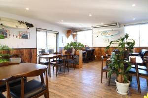 a restaurant with tables and chairs and plants at SWELL in Hyuga