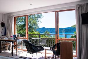 a room with a balcony with a view of the water at Picton Paradise Cottages in Picton +6 photos