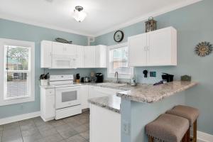 a kitchen with white appliances and blue walls at Boogie Man 36C By Pkrm in Pensacola