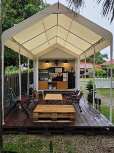 a gazebo with chairs and tables on a wooden deck at Casa Yusika in Pantai Cenang