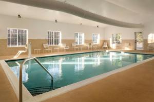 a large swimming pool in a building with chairs at City Express by Marriott Danville in Danville