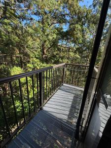ein Balkon mit Blick auf den Wald in der Unterkunft 最大4名の城ノ浜プール近くの宿 in Kihokucho