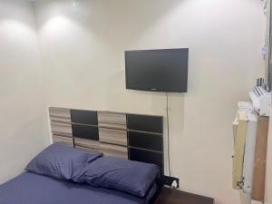 a bedroom with a bed and a flat screen tv on the wall at Podium Empire in Lekki