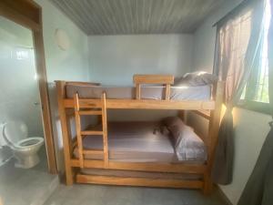 two bunk beds in a room with a toilet at El Castillo in Moñitos