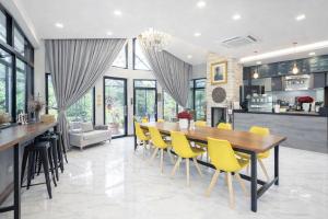 a dining room with a table and yellow chairs at Rayong Valley Resort in Ban Khao Chak Khaek (1)