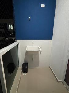 a bathroom with a sink and a blue wall at Estúdio Fit Caiobá - Matinhos in Matinhos +9 photos