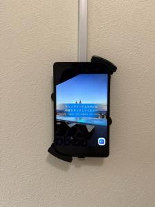 Ein Handy hängt an einer Wand in der Unterkunft 最大4名の城ノ浜プール近くの宿 in Kihokucho
