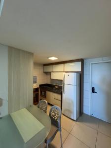 a kitchen with a refrigerator and a table and chairs at Flat beira mar Olinda Jam in Olinda
