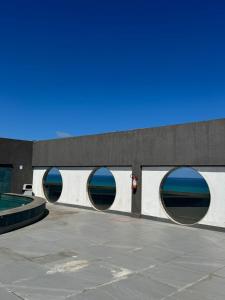 a building with three circular windows with the ocean in the background at Flat beira mar Olinda Jam in Olinda