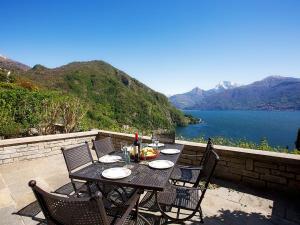 メナッジョにあるBelvedere Menaggio-4 Luxury homes-by Italian Apartments Casa Paradiso, Apartmento Belvedere, Woon Belvedere Apartment Penthouse, VH apartment Bella Vistaの湖の景色を望むパティオ(テーブル、椅子付)