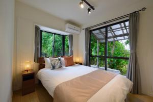 a bedroom with a bed and a large window at 064Villa 美海璃 in Nanjo +79 photos