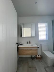a white bathroom with a sink and a toilet at Sea Escape in Whitianga +5 photos