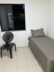 a bedroom with a bed and a table next to a window at Cantinho da Aruana, conforto e tranquilidade in Aracaju +12 photos