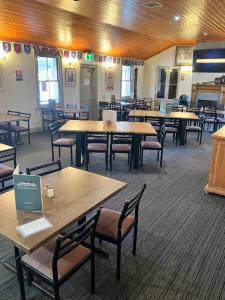 a large room with tables and chairs in a building at Berridale Inn in Berridale