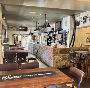 a restaurant with tables and chairs and a bar at Berridale Inn in Berridale