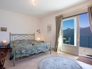 メナッジョにあるBelvedere Menaggio-4 Luxury homes-by Italian Apartments Casa Paradiso, Apartmento Belvedere, Woon Belvedere Apartment Penthouse, VH apartment Bella Vistaのベッドとガラスの引き戸のある寝室