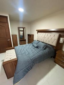 a bedroom with a large bed with a blue blanket at Casa Mexiquito in Arandas
