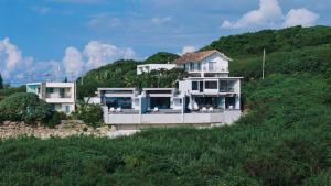 a house sitting on top of a hill at Villa Azure Mira in Miyakojima