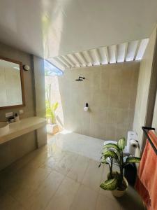 a bathroom with a shower and a sink and a plant at Twin Palms Rote in Nembrala +59 photos
