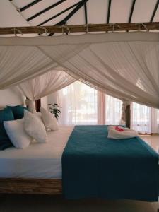 a bedroom with a bed with a canopy at Twin Palms Rote in Nembrala