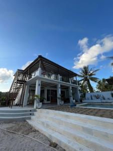 a house on the beach with stairs leading up to it at Twin Palms Rote in Nembrala