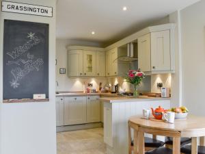 a kitchen with yellow cabinets and a table and a chalkboard at Rooftops - Uk34065 in Grassington