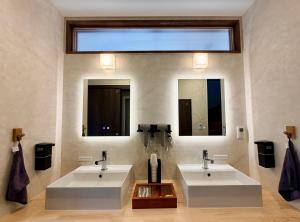 a bathroom with two sinks and two mirrors at Three Maples Fujiyoshida in Fujiyoshida