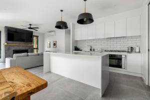 a white kitchen with a table and a couch at Coastal Ember in Inverloch