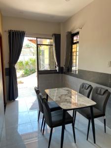 a dining room with a table and chairs at Tổ Nhím Homestay in Ấp Cái Chuối
