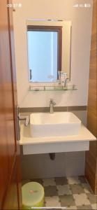 a bathroom with a sink and a mirror and a toilet at Khách sạn Kiến Đức in Kiến Ðức