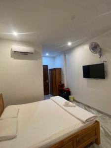 a bedroom with a bed with a tv on the wall at Khách sạn Kiến Đức in Kiến Ðức