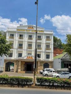 a white building with cars parked in front of it at Khách sạn Kiến Đức in Kiến Ðức +6 photos