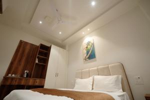 a bedroom with a bed with white sheets and pillows at Hotel Highton in Hānsi +5 photos