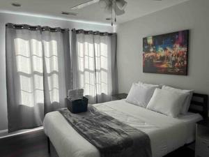 a bedroom with a bed with white sheets and windows at 25 Lux Room 2 - 1 Queen Bed, Shared Bathroom - Nonsmoking in Arlington