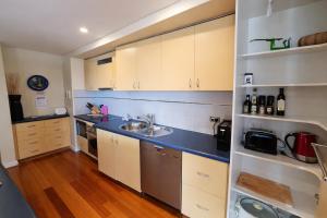 a kitchen with white cabinets and a blue counter top at Ocean View-breath Taking Views, Amazing Facilities in Perth