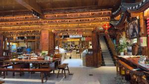 a restaurant with tables and chairs and a staircase at Tu Wang Ju Ke Zhan in Yongshun