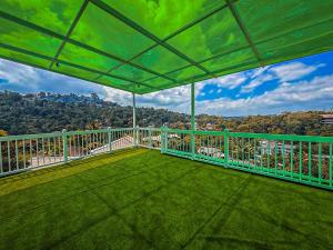 a balcony with a green roof with a view at Nature Breeze Boutique Villa in Kandy
