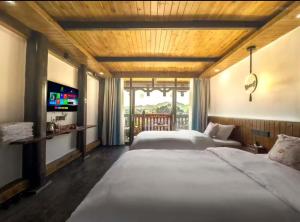 a bedroom with two beds and a television in it at Tu Wang Ju Ke Zhan in Yongshun