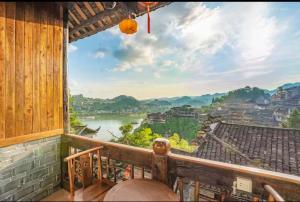 a balcony with a view of a river and buildings at Tu Wang Ju Ke Zhan in Yongshun