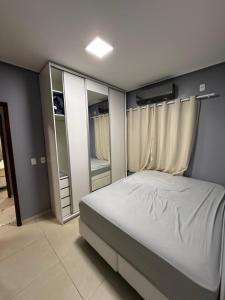 a bedroom with a white bed and some mirrors at CASA DE PRAIA EM PRAIA BELA PITIMBu PB in Pitimbu