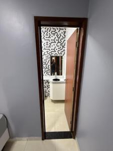 a mirror in a bathroom with a sink and a person at CASA DE PRAIA EM PRAIA BELA PITIMBu PB in Pitimbu +4 photos