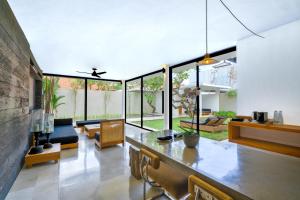 a living room with a large glass wall at Uma Sapna Seminyak in Seminyak
