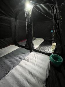 a black tent with a white bed in it at Rasa Durio Eco Glampz in Rasa