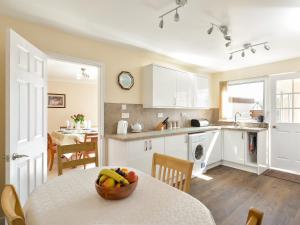 a kitchen with a table with a bowl of fruit on it at Westburn in Comrie