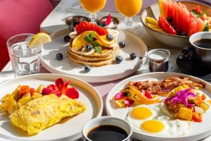 a table topped with plates of breakfast foods and drinks at Waldorf Towers South Beach in Miami Beach