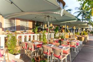 a restaurant with tables and chairs under an umbrella at Waldorf Towers South Beach in Miami Beach