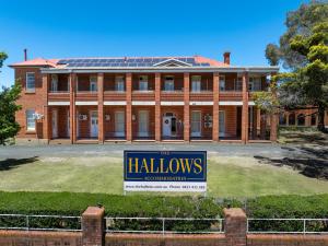 a large brick house with a sign in front of it at The Hallows Accommodation in Bathurst